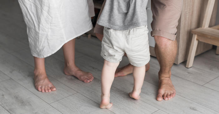 Benene til en mor far og barn som står barbeint på et gulv