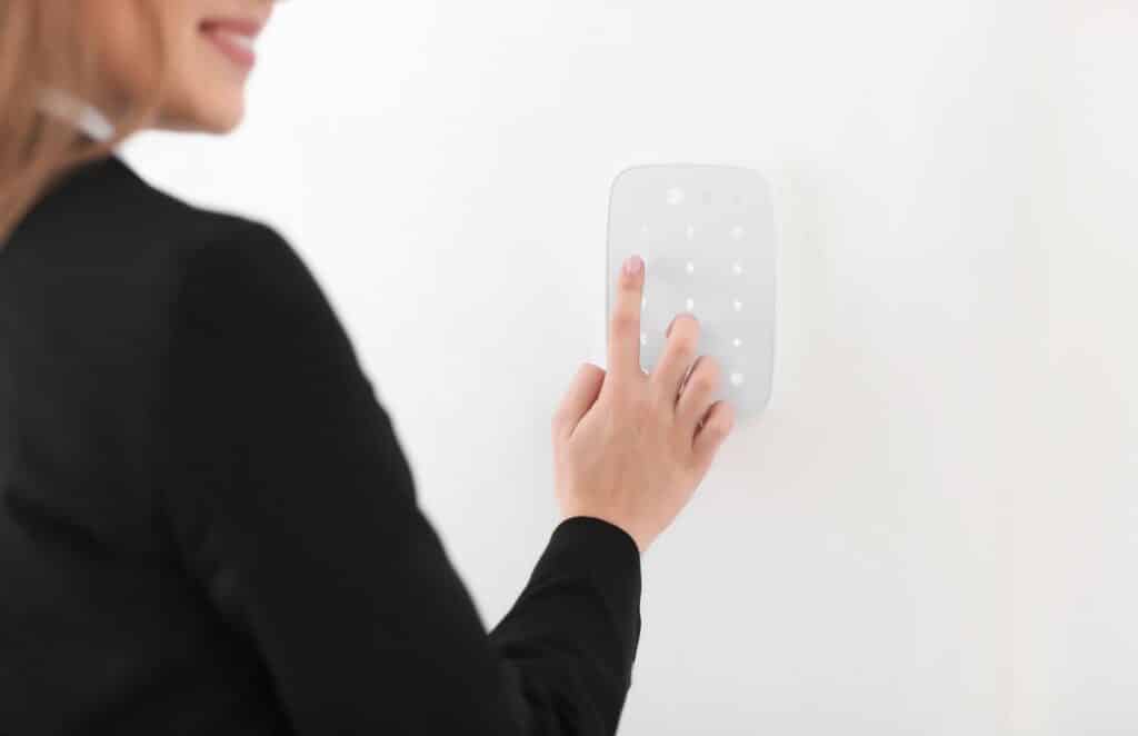 Kvinne som trykker på et panel til en boligalarm